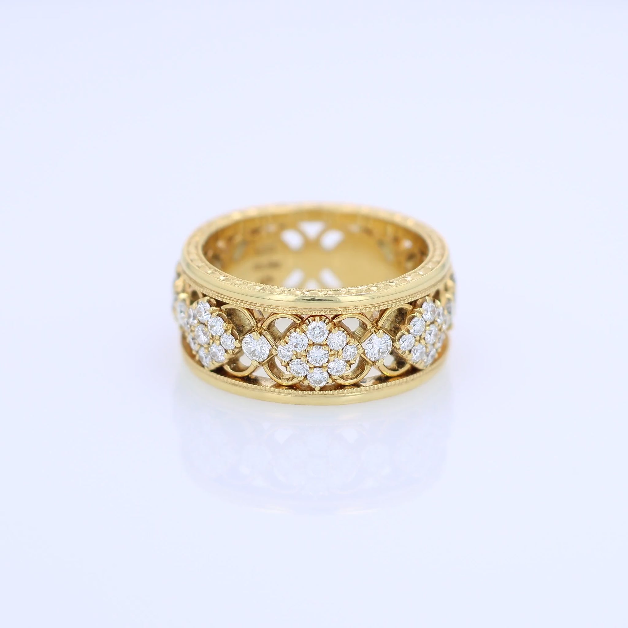 Yellow gold ring with diamond accents on a white background