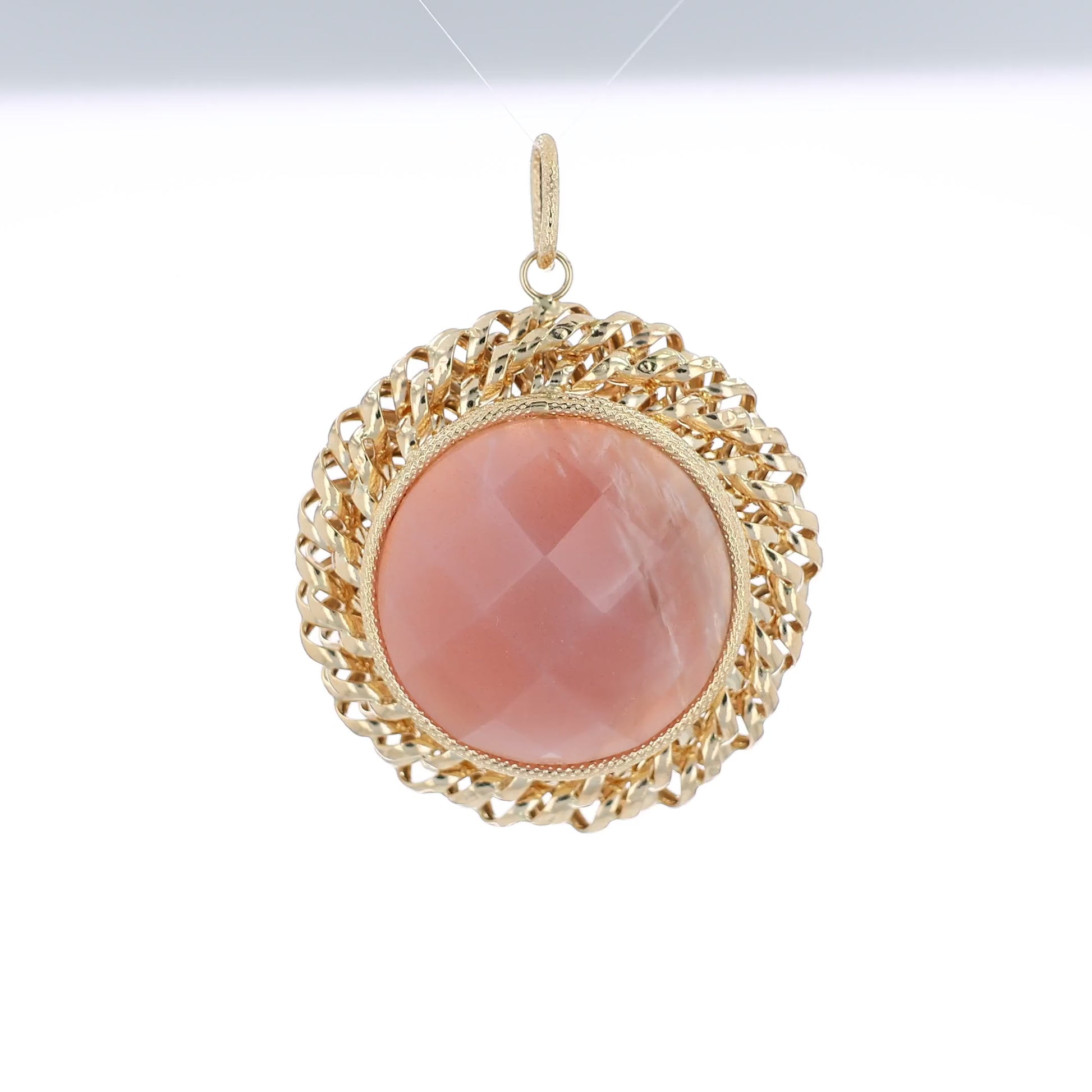 Yellow gold faceted round pink agate pendant with a textured rope border and a polished swirl frame on a white background
