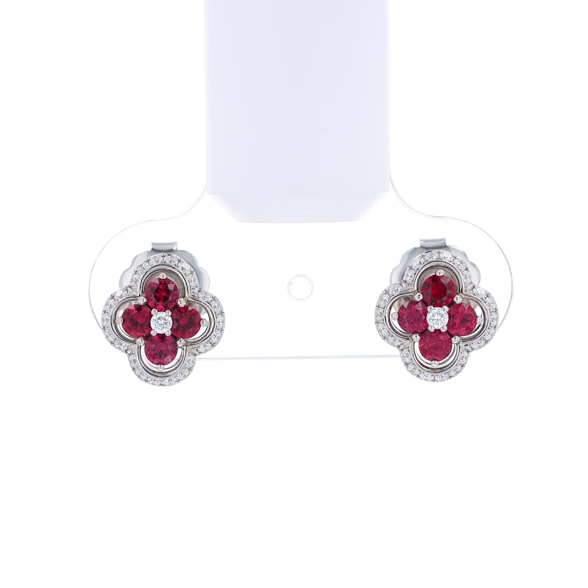 White gold stud earrings with diamond and ruby accents on a white background