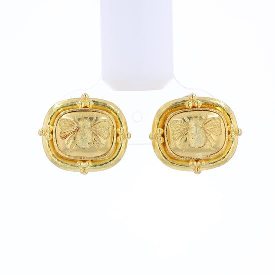 Textured yellow gold stud earrings with an embossed bee design on a white background