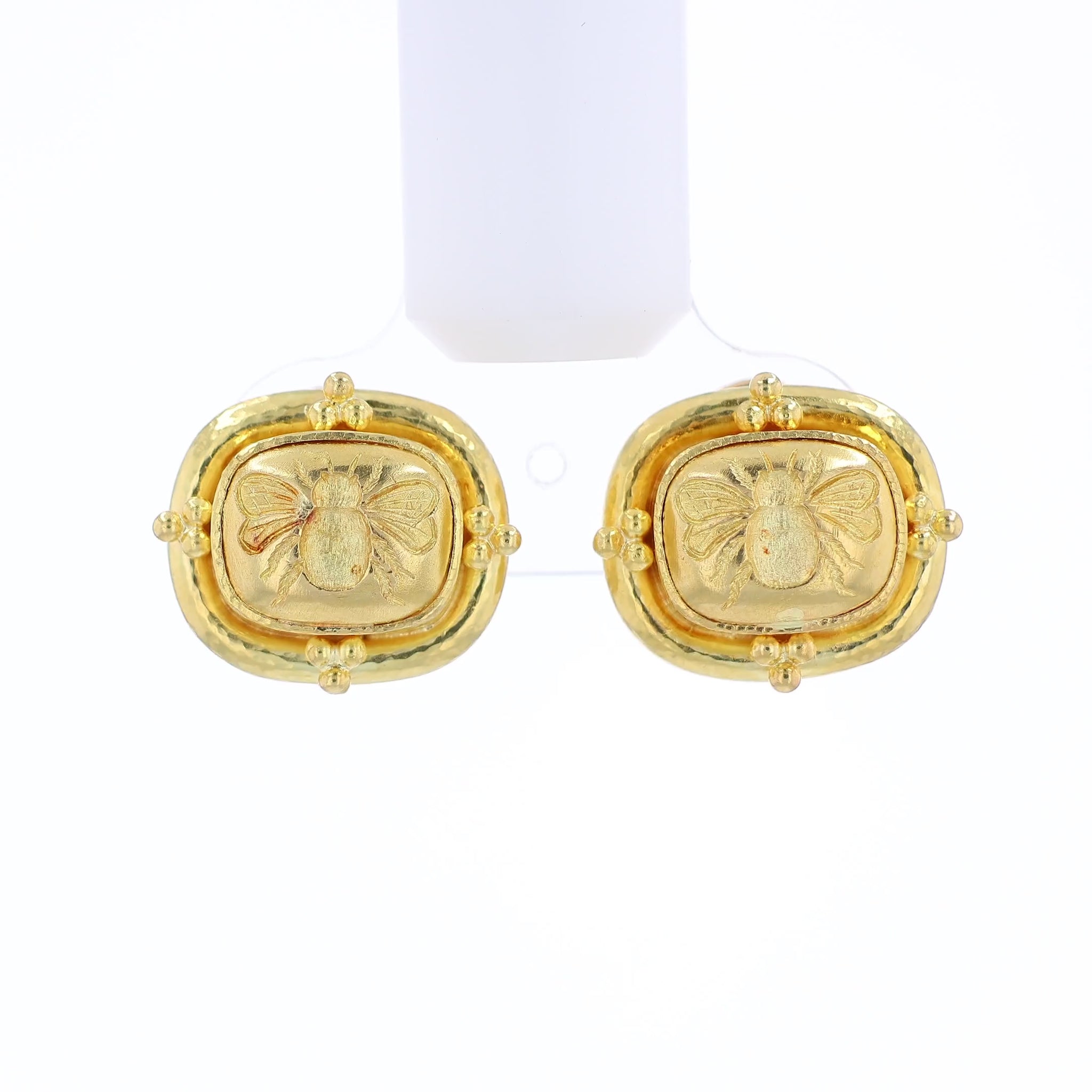 Textured yellow gold stud earrings with an embossed bee design on a white background