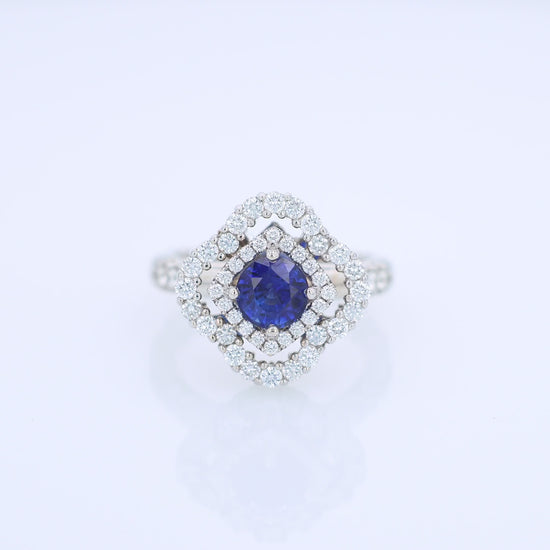 White gold diamond double halo ring with a blue sapphire center stone on a white background