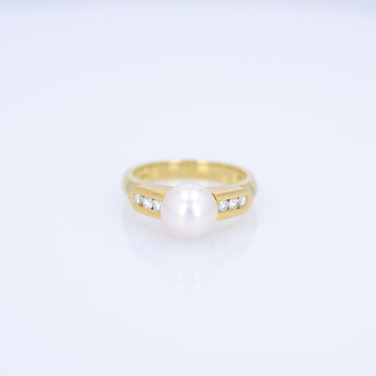 Yellow gold akoya pearl and diamond row ring on a white background