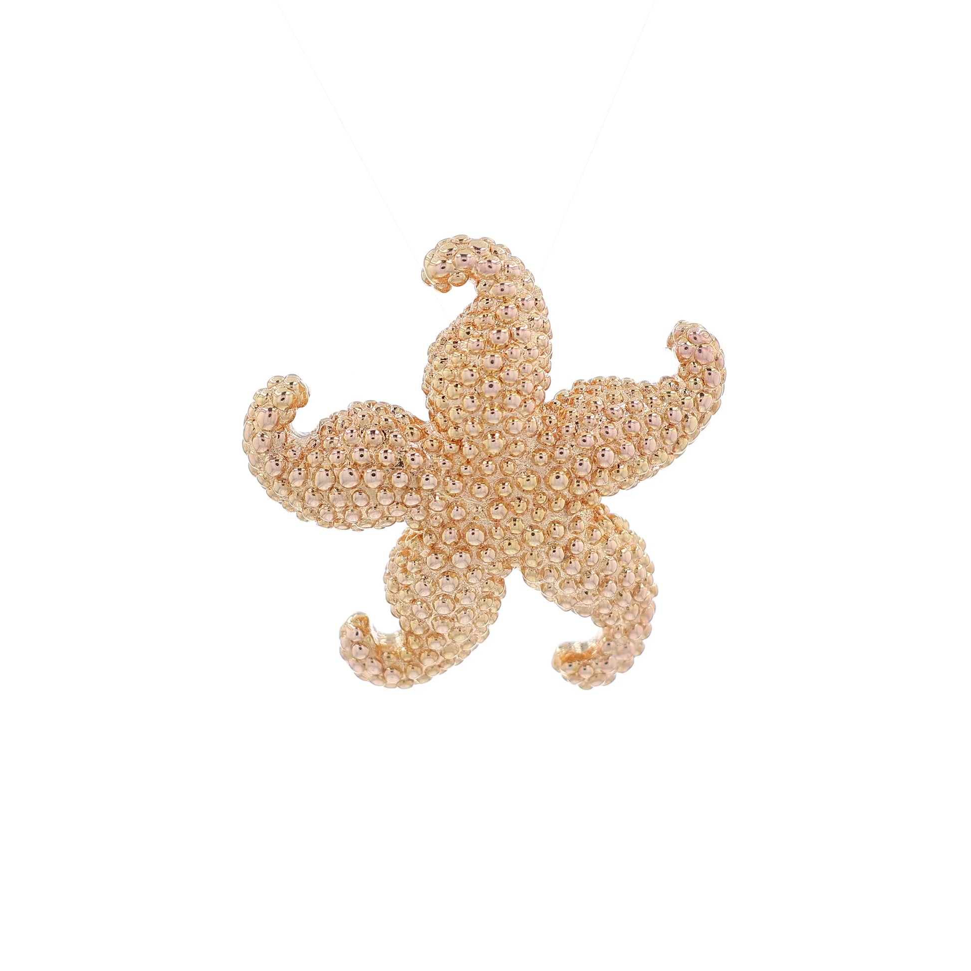 A video of a yellow gold textured starfish design pin on a white background