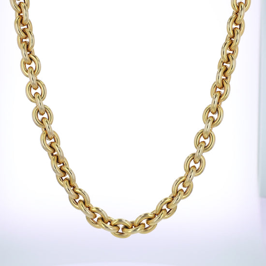 Yellow gold oval link chain necklace on a white background