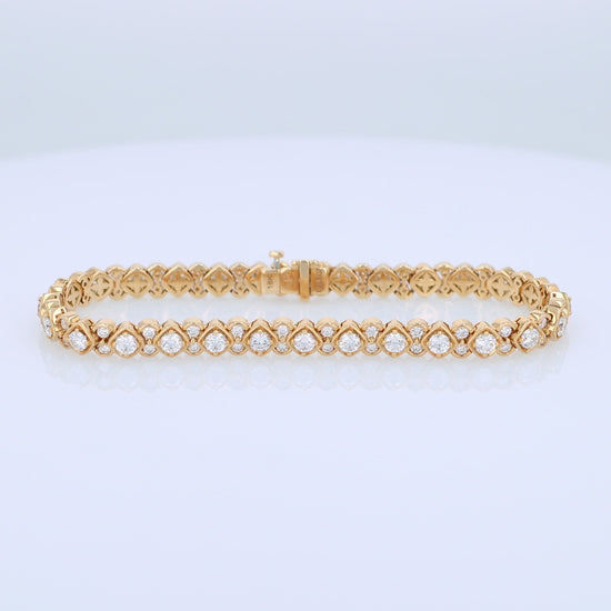 Yellow gold bracelet with diamond accents on a white background