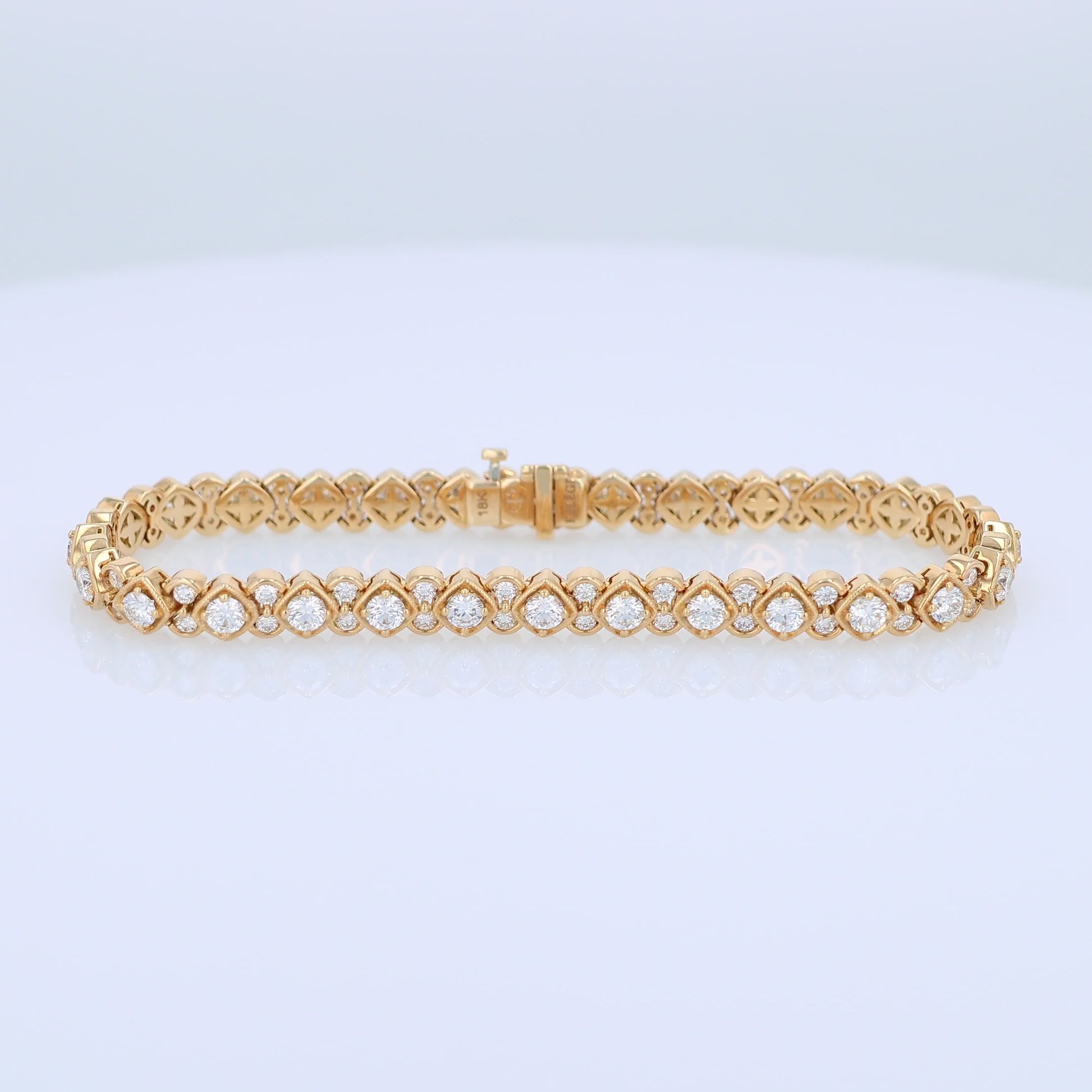 Yellow gold bracelet with diamond accents on a white background