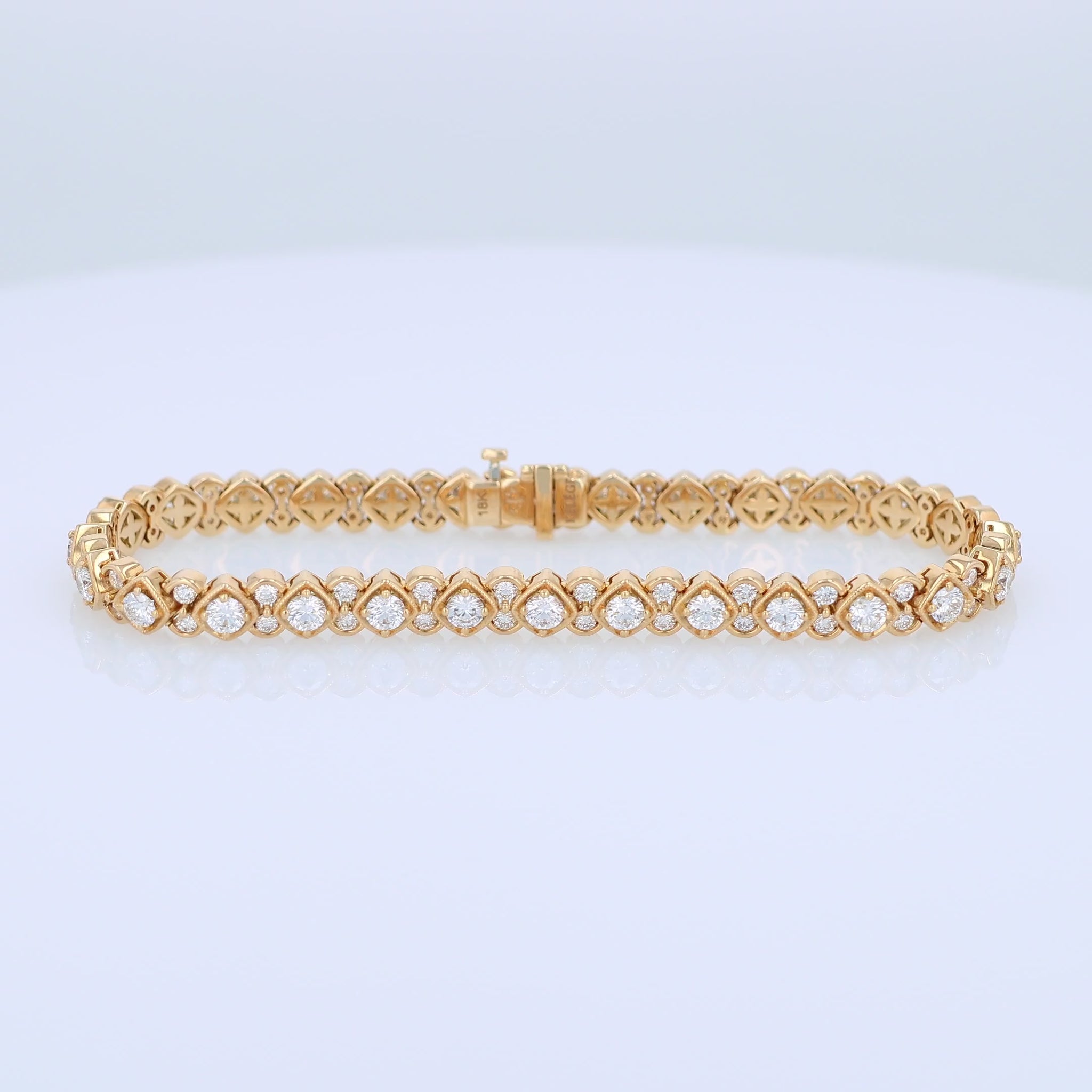 Yellow gold bracelet with diamond accents on a white background