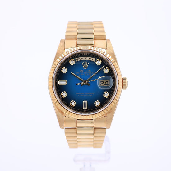 360 degree video of a yellow gold Rolex watch with a blue dial and diamond indexes on a white background