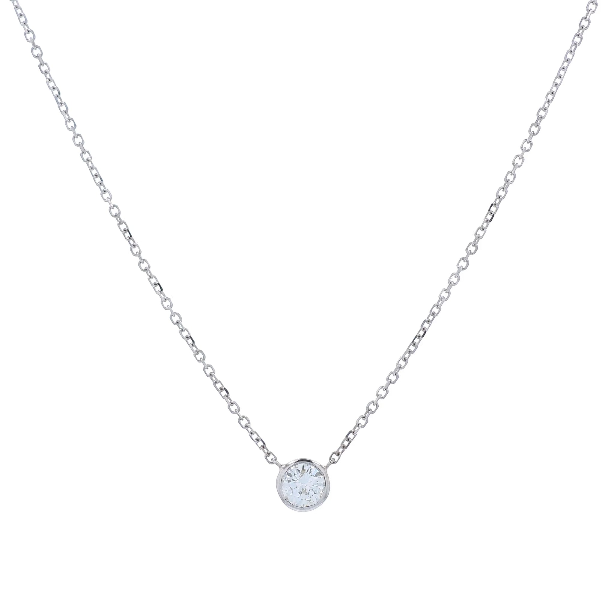 A delicate white gold chain necklace with a single round bezel-set diamond pendant, displayed on a clean white background.