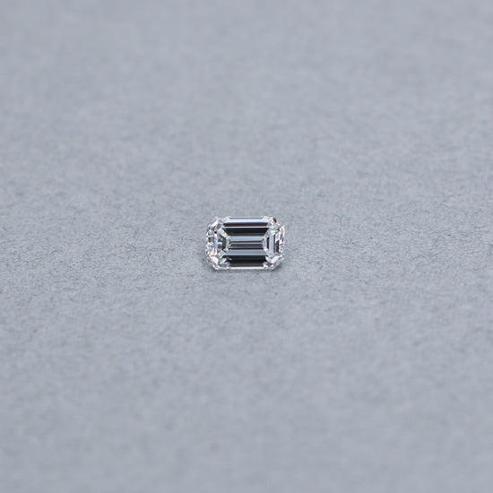Emerald cut 1.03 carat GIA certified diamond graded DVS1 on a grey background