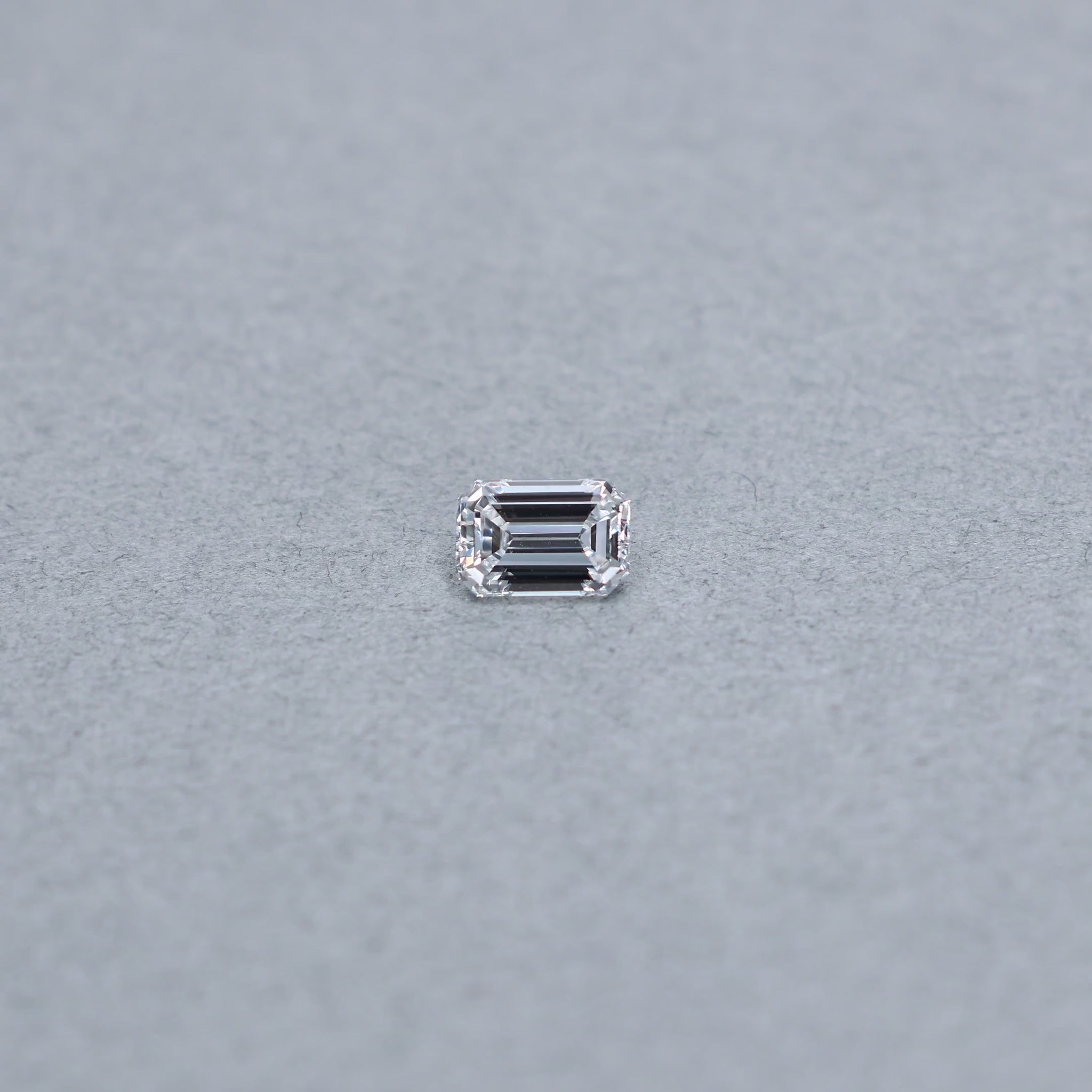 Emerald cut 1.03 carat GIA certified diamond graded DVS1 on a grey background