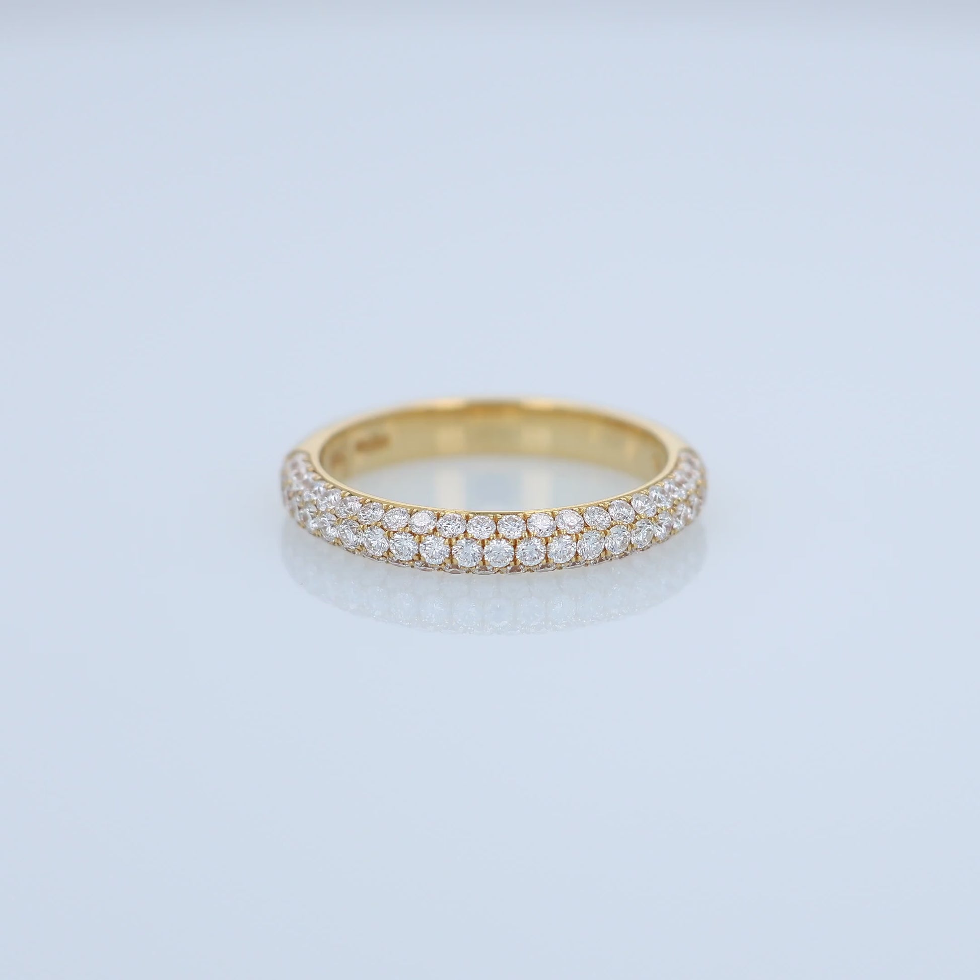 Yellow gold ring with embedded diamonds on a white background