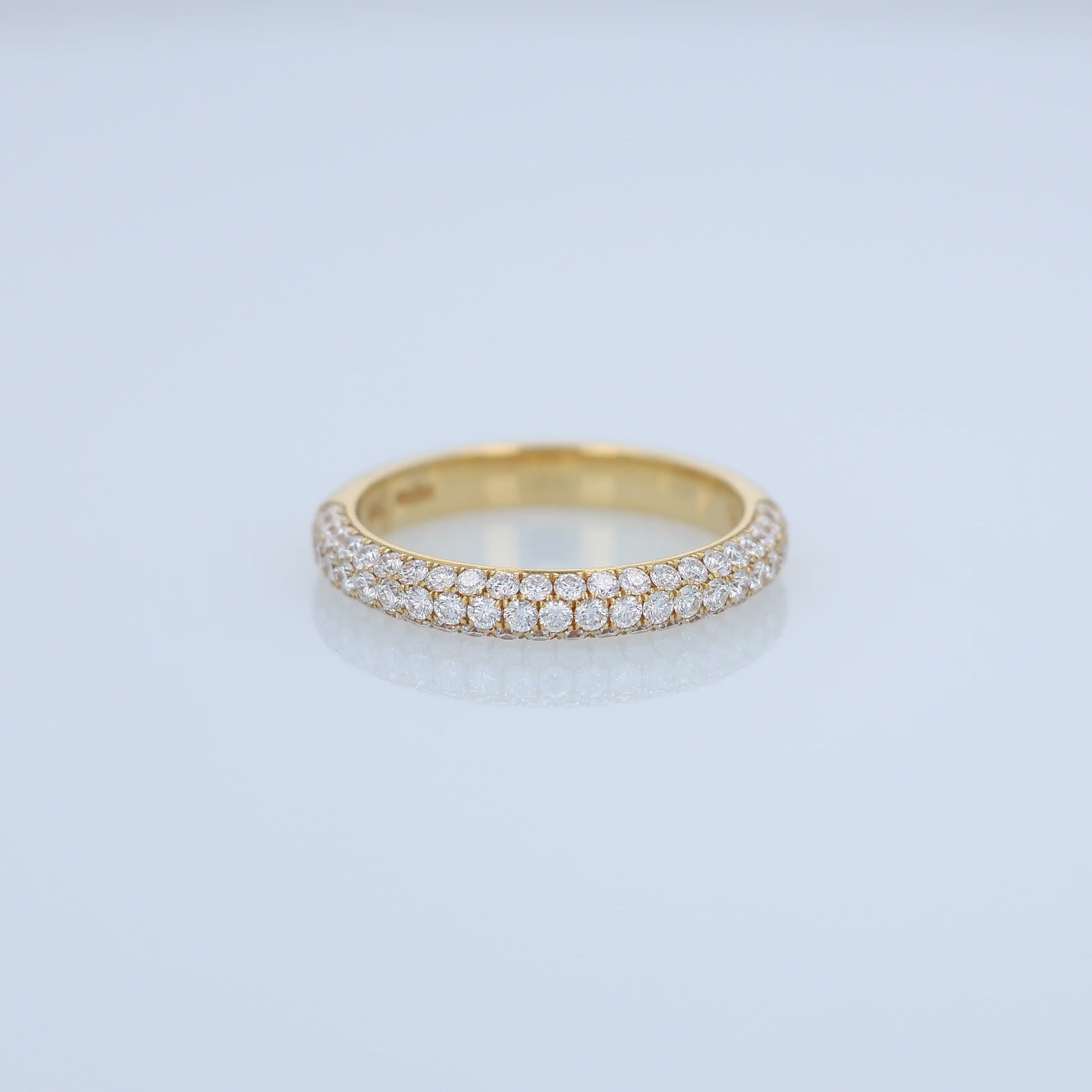 Yellow gold ring with embedded diamonds on a white background