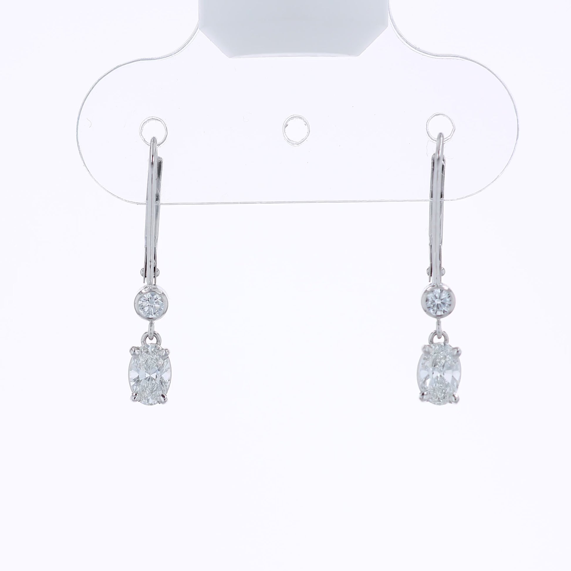 White gold round and oval diamond drop earrings on a white background
