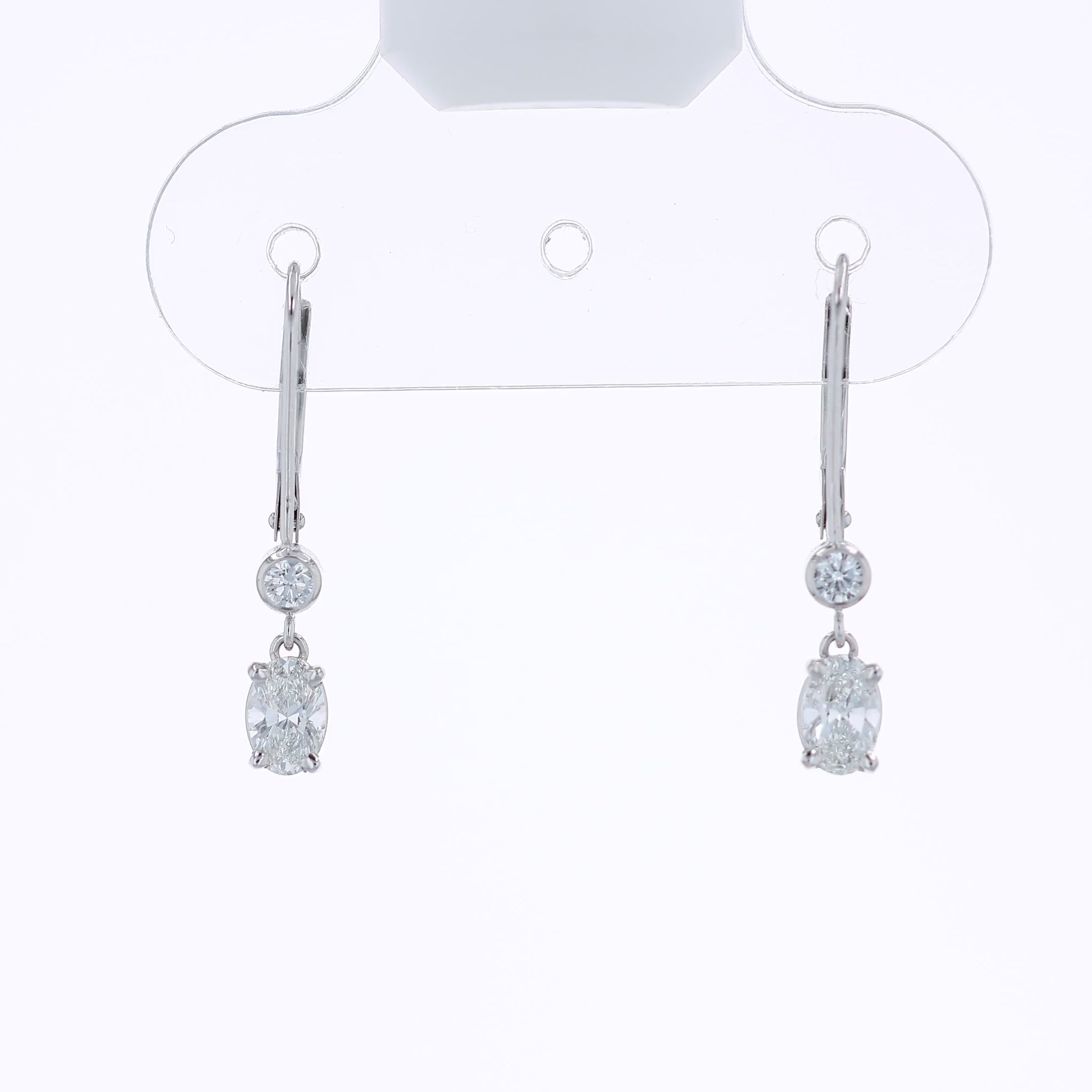 White gold round and oval diamond drop earrings on a white background