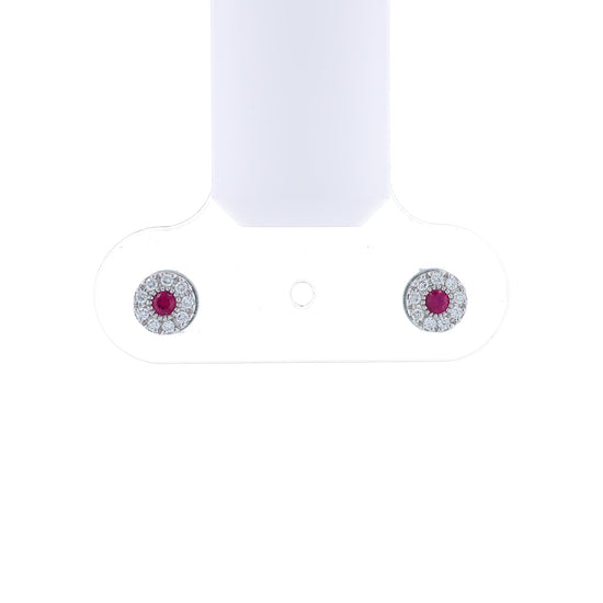 White gold round ruby and diamond halo stud earrings on a white background