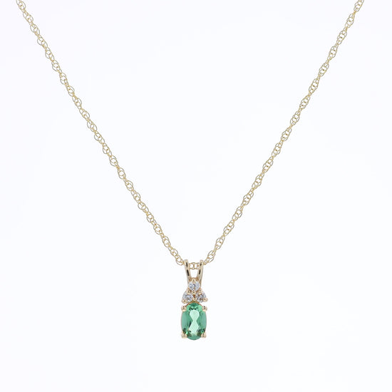 Yellow gold oval natural alexandrite and diamond pendant necklace on a white background