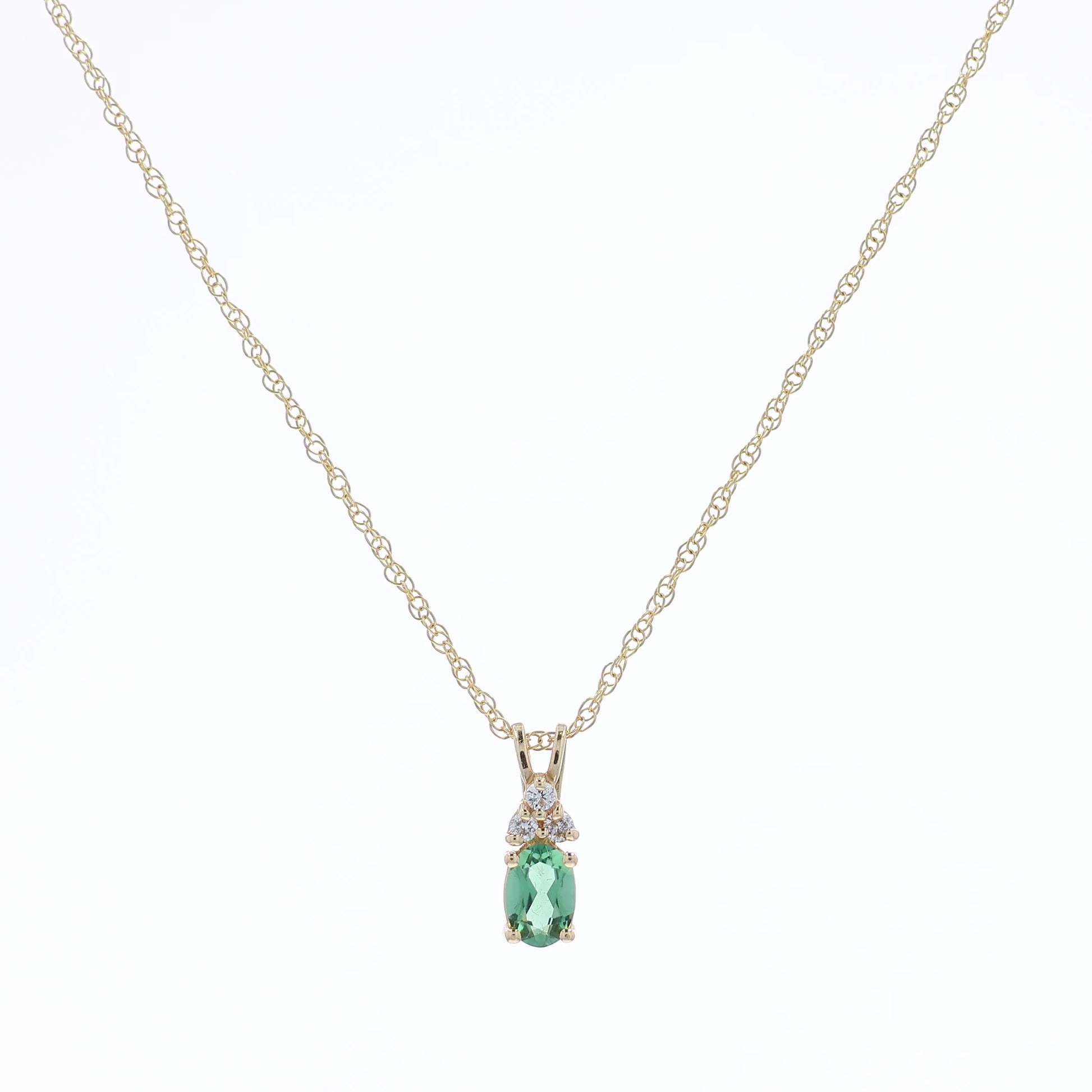 Yellow gold oval natural alexandrite and diamond pendant necklace on a white background