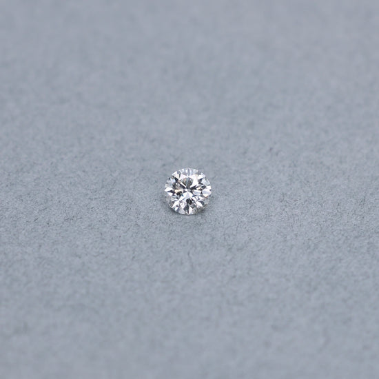 Round .63 carat GIA certified diamond graded GSI2 on a grey background
