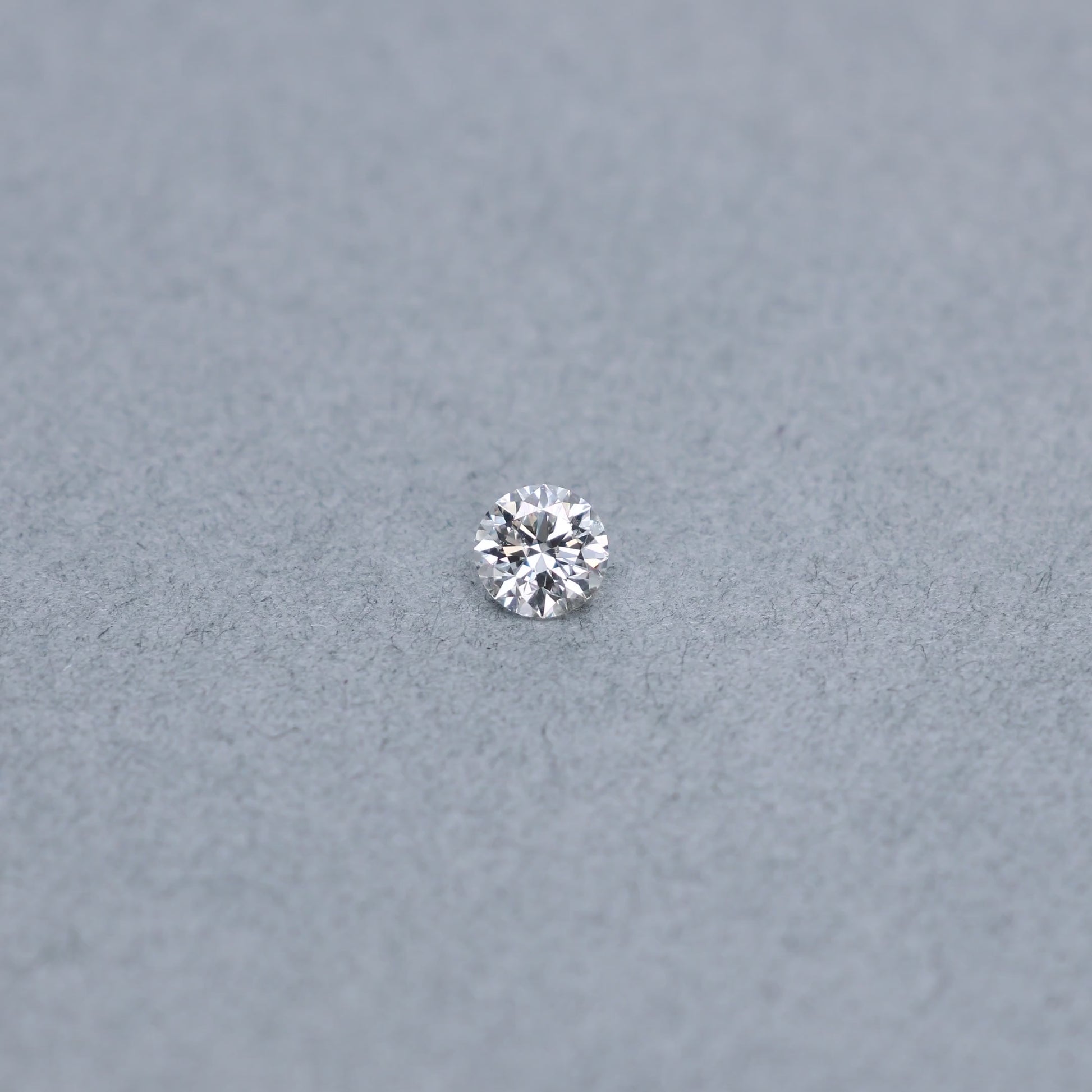 Round .63 carat GIA certified diamond graded GSI2 on a grey background