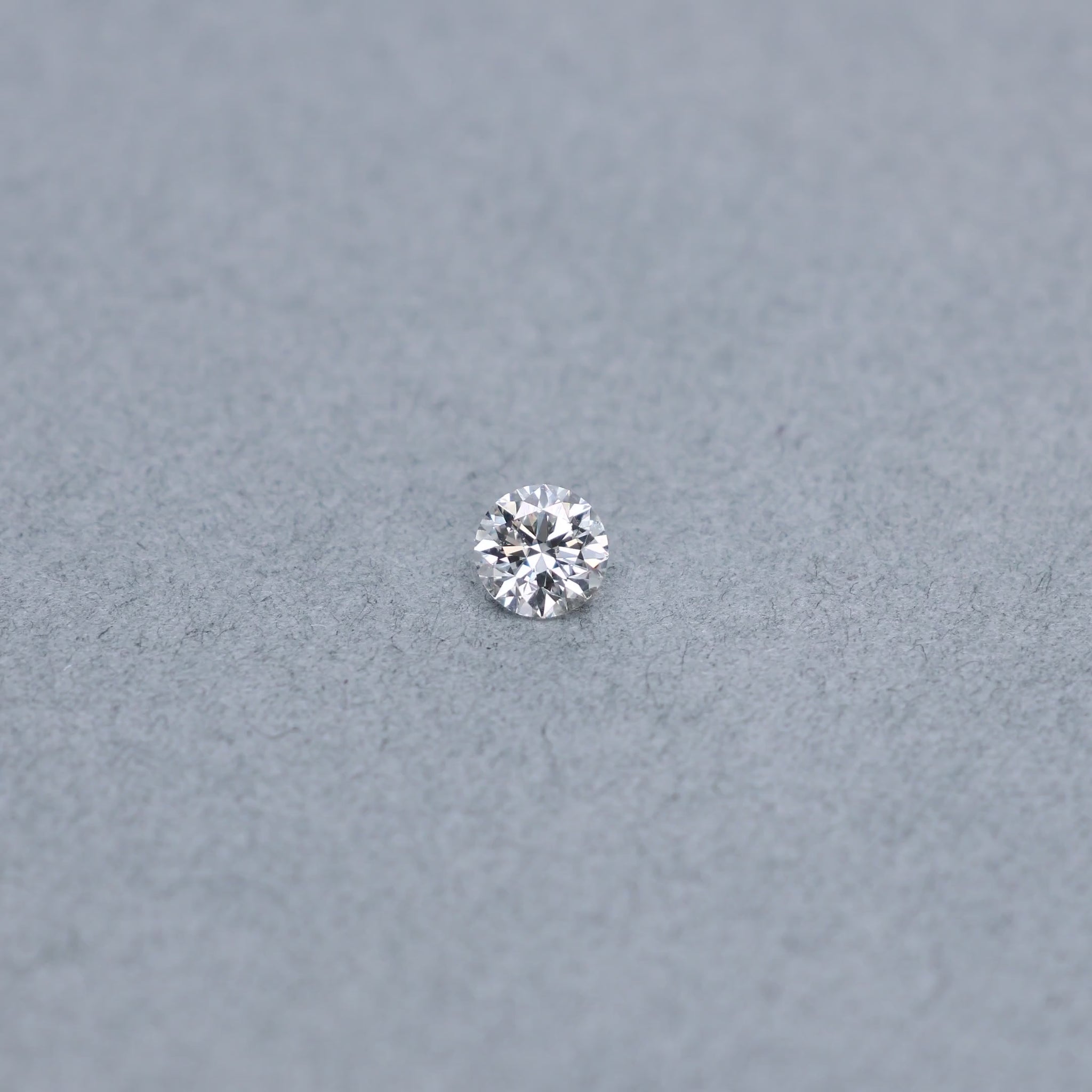 Round .63 carat GIA certified diamond graded GSI2 on a grey background