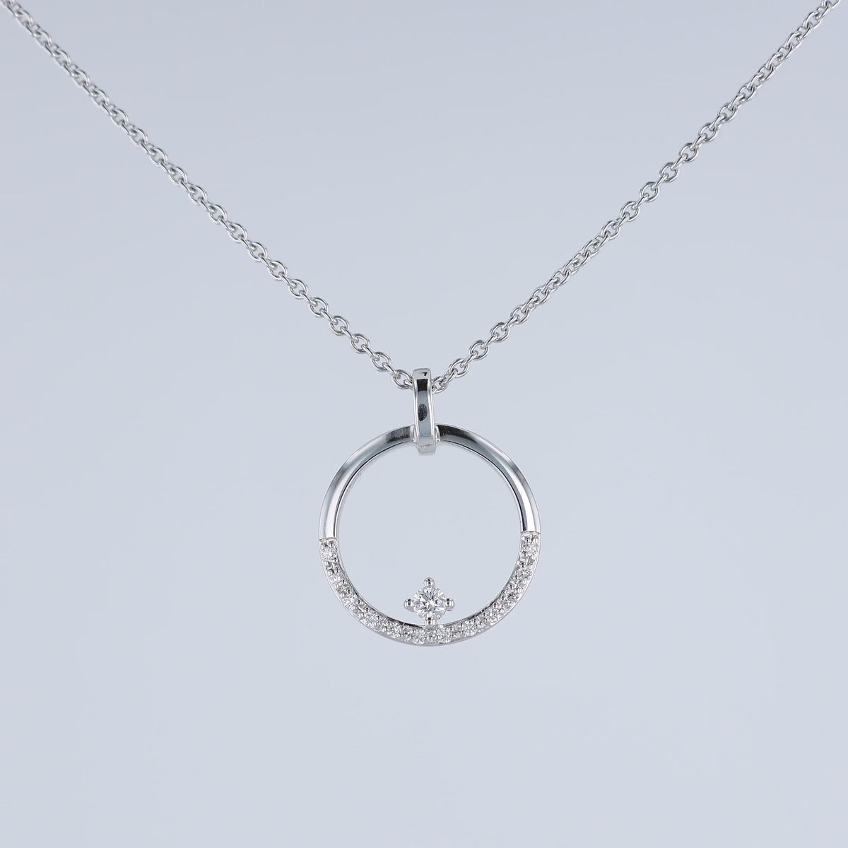 A video of a white gold chain necklace with a circular pendant featuring a small crown motif and clear stones, shown at various angles on a white background with a faint reflection below.
