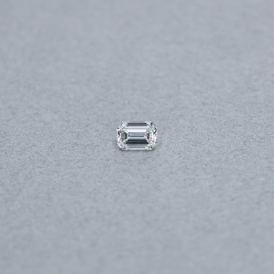 Emerald Cut .90 carat GIA certified diamond graded GVS1 on a grey background