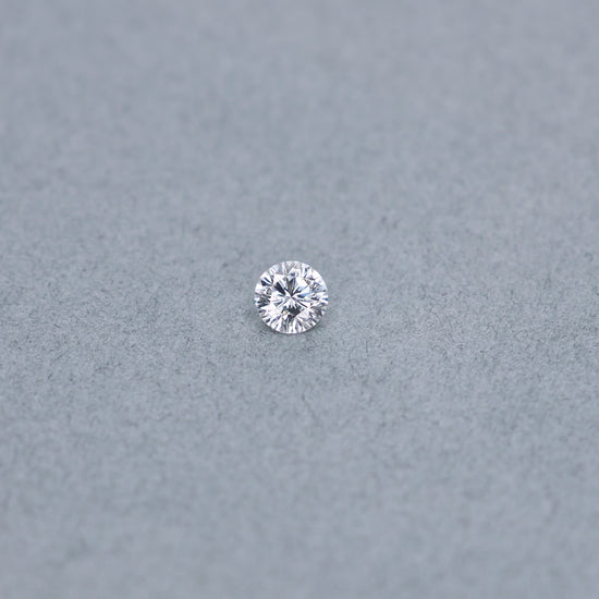 Round .61 carat modified diamond graded ESI2 on a grey background