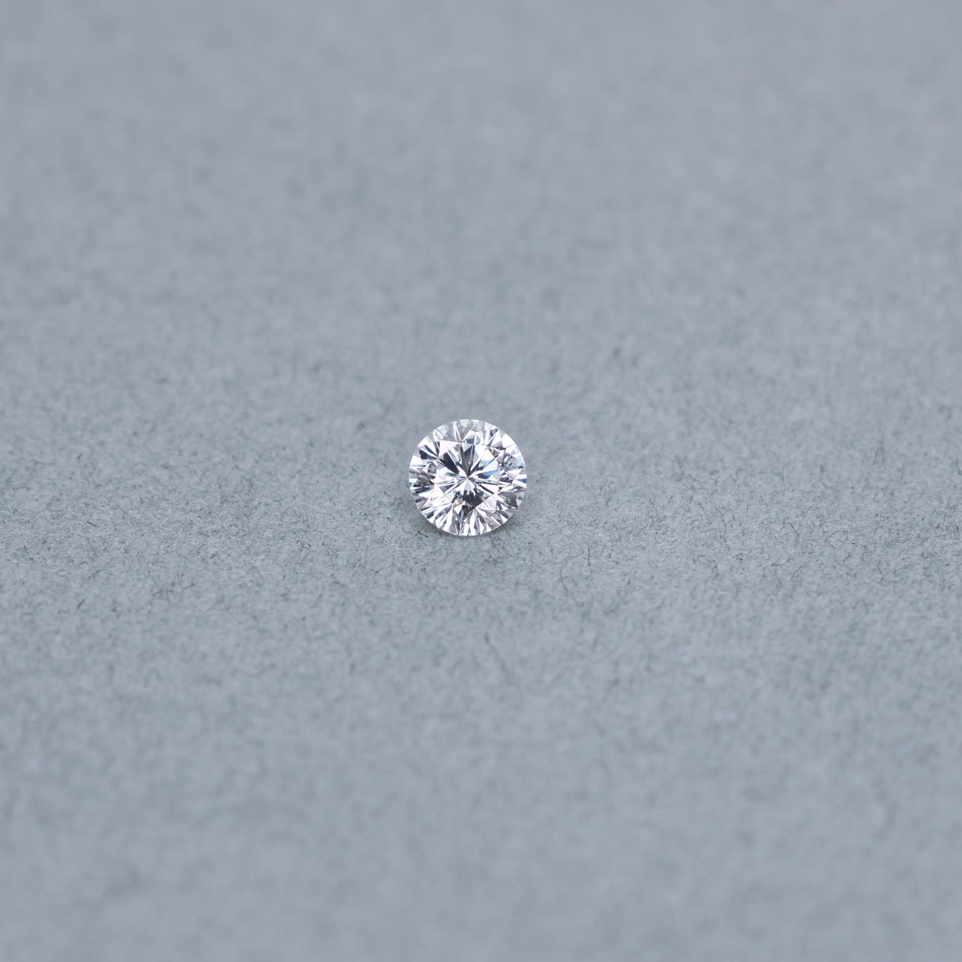 Round .61 carat modified diamond graded ESI2 on a grey background