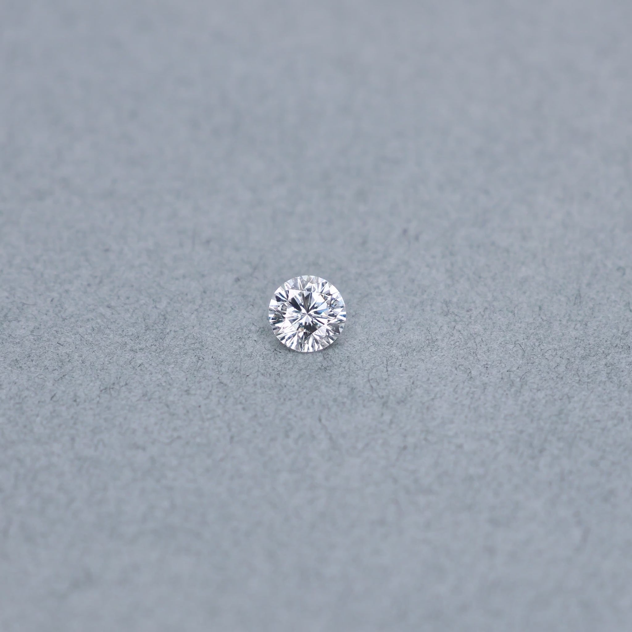 Round .61 carat modified diamond graded ESI2 on a grey background