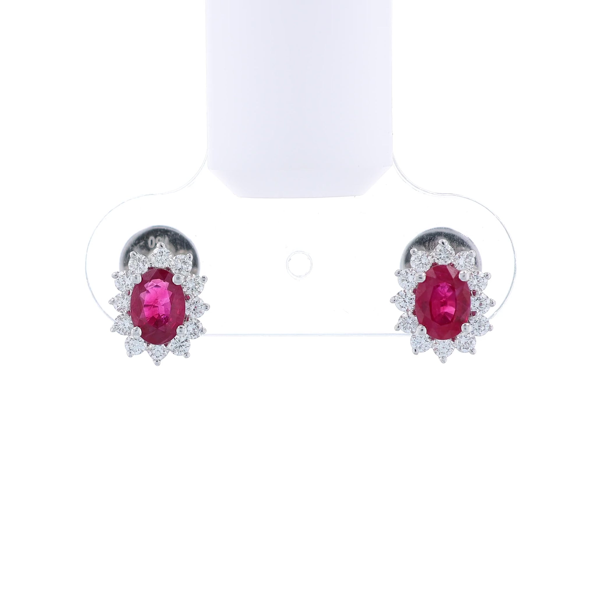 Pair of white gold diamond halo earrings with oval ruby centers on a white background