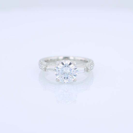 Platinum diamond engagement ring with diamond accents and a round cubic zirconia center on a white background