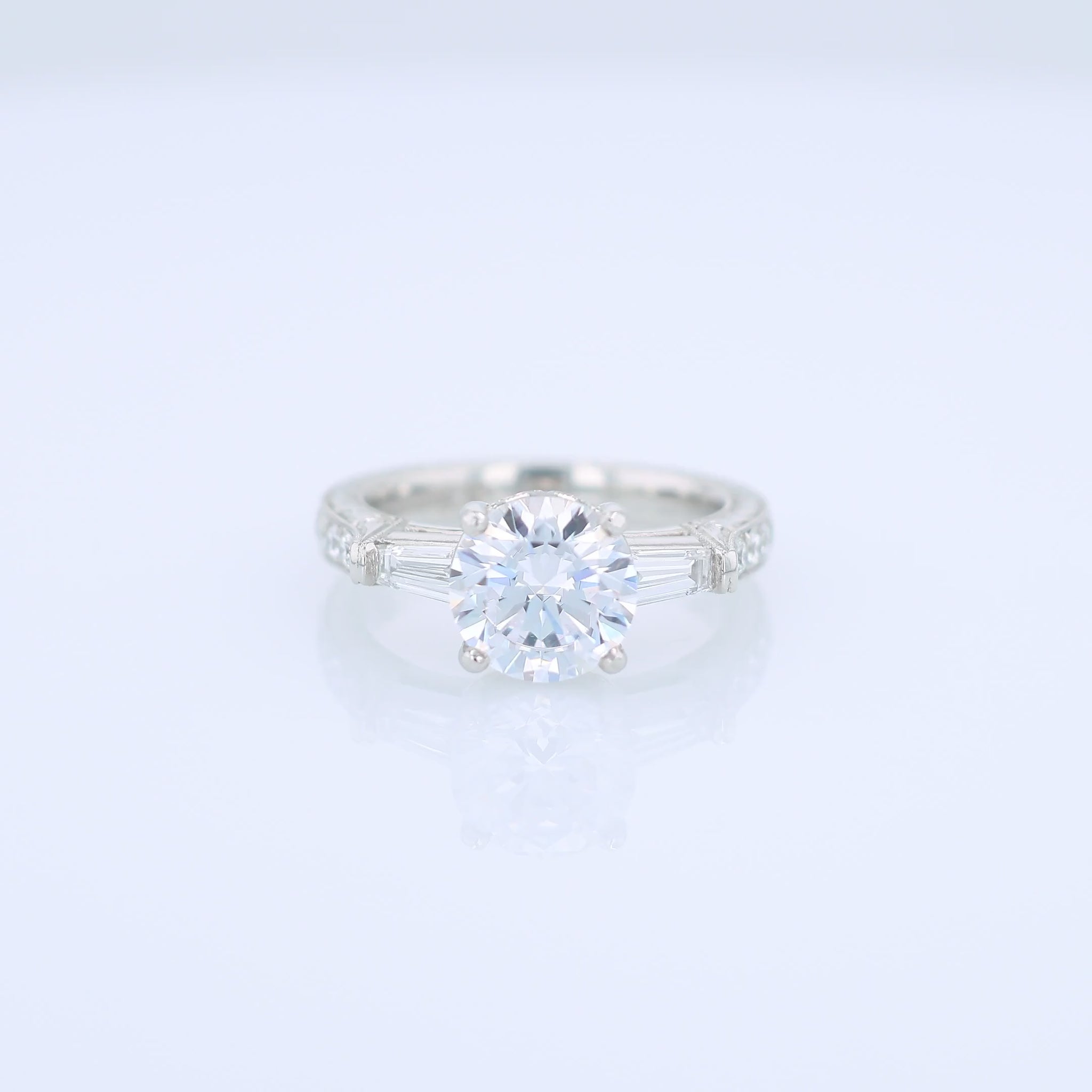 Platinum diamond engagement ring with diamond accents and a round cubic zirconia center on a white background