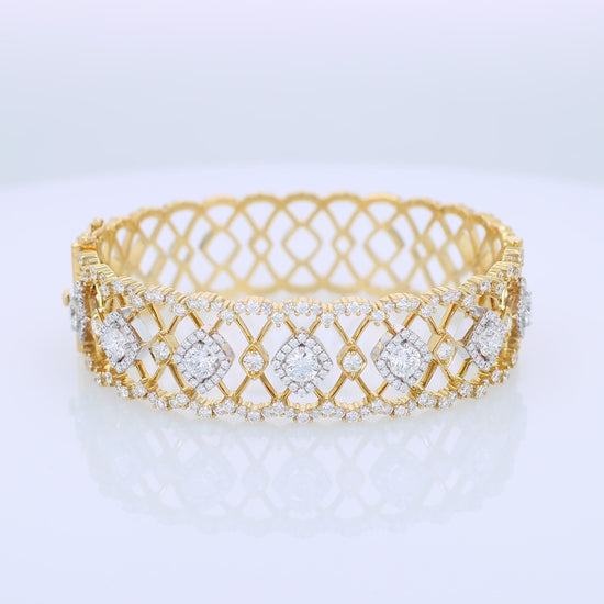 Gold open work design bracelet with diamond accents on a white background