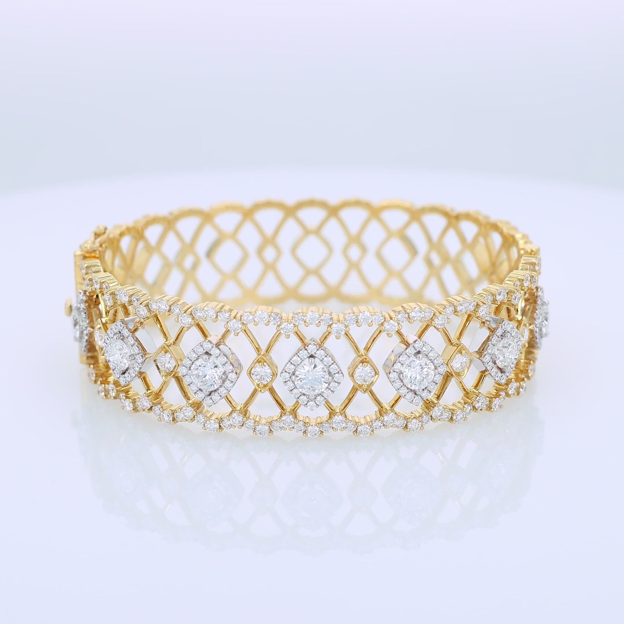 Gold open work design bracelet with diamond accents on a white background
