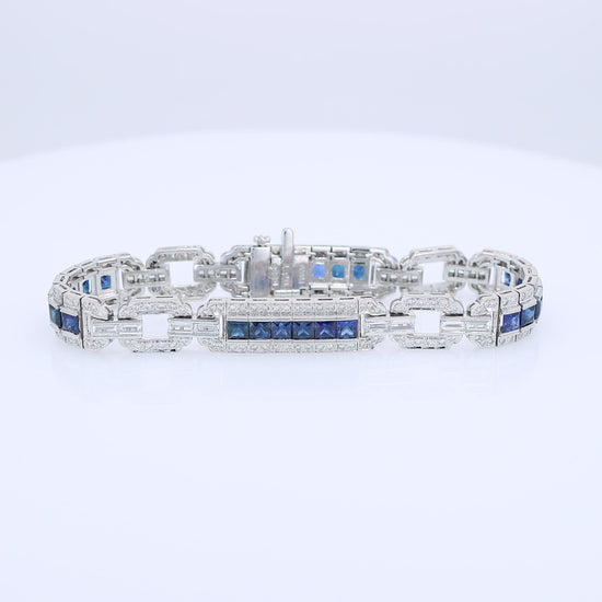 Platinum alternating synthetic sapphire and diamond link bracelet on a white background