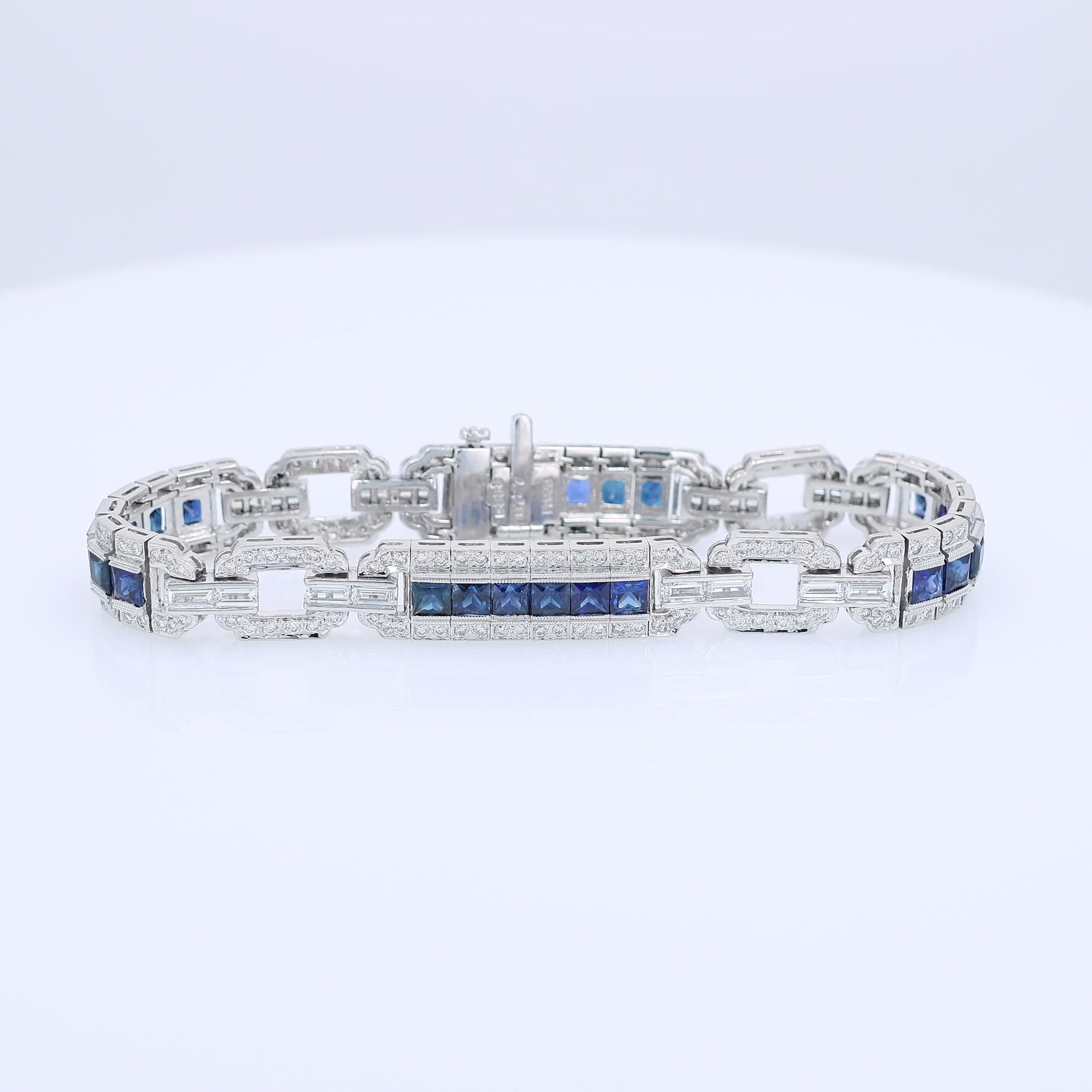 Platinum alternating synthetic sapphire and diamond link bracelet on a white background