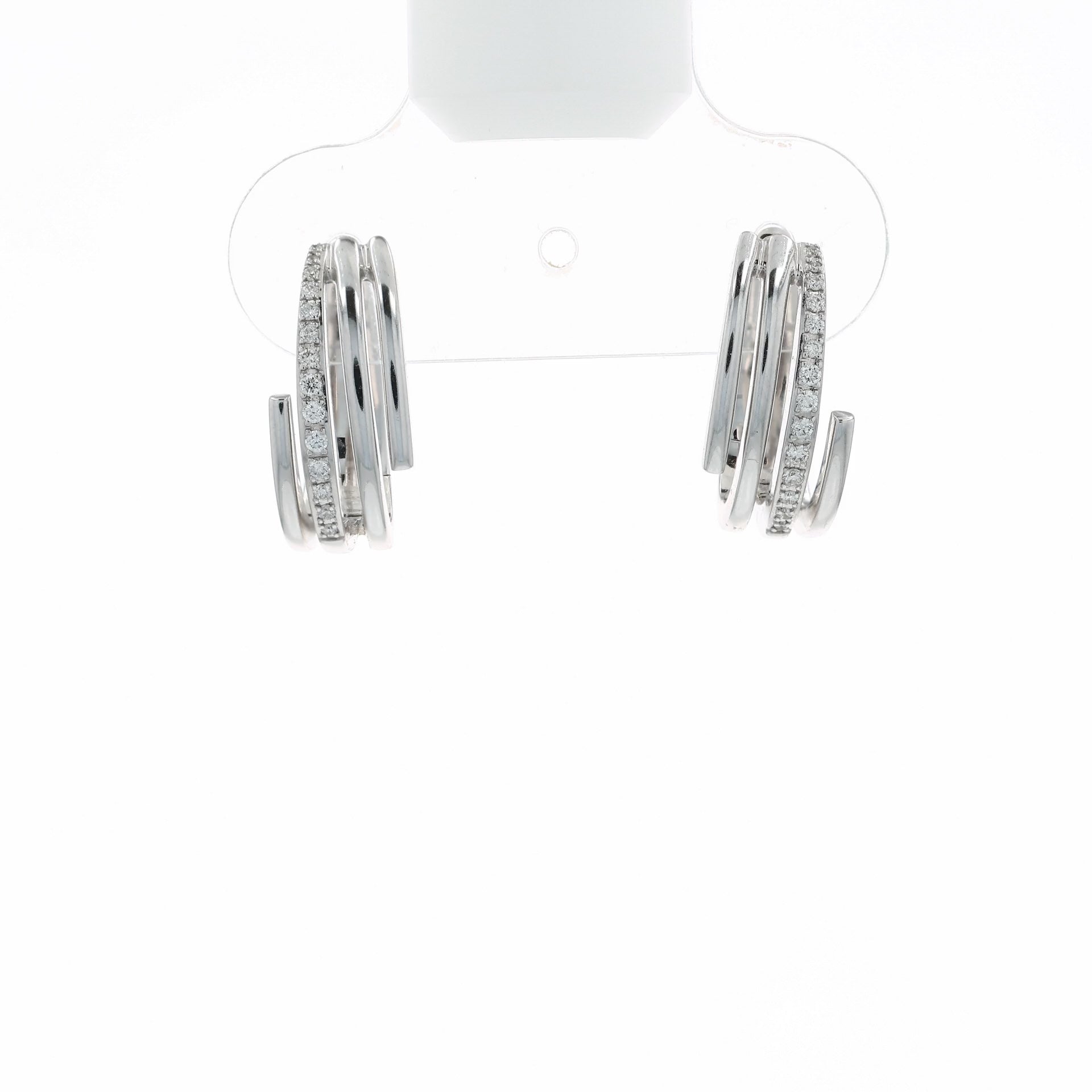 A video of a pair of white gold wrap-around hoop earrings with rows of small clear stones, shown at various angles on a clean white background