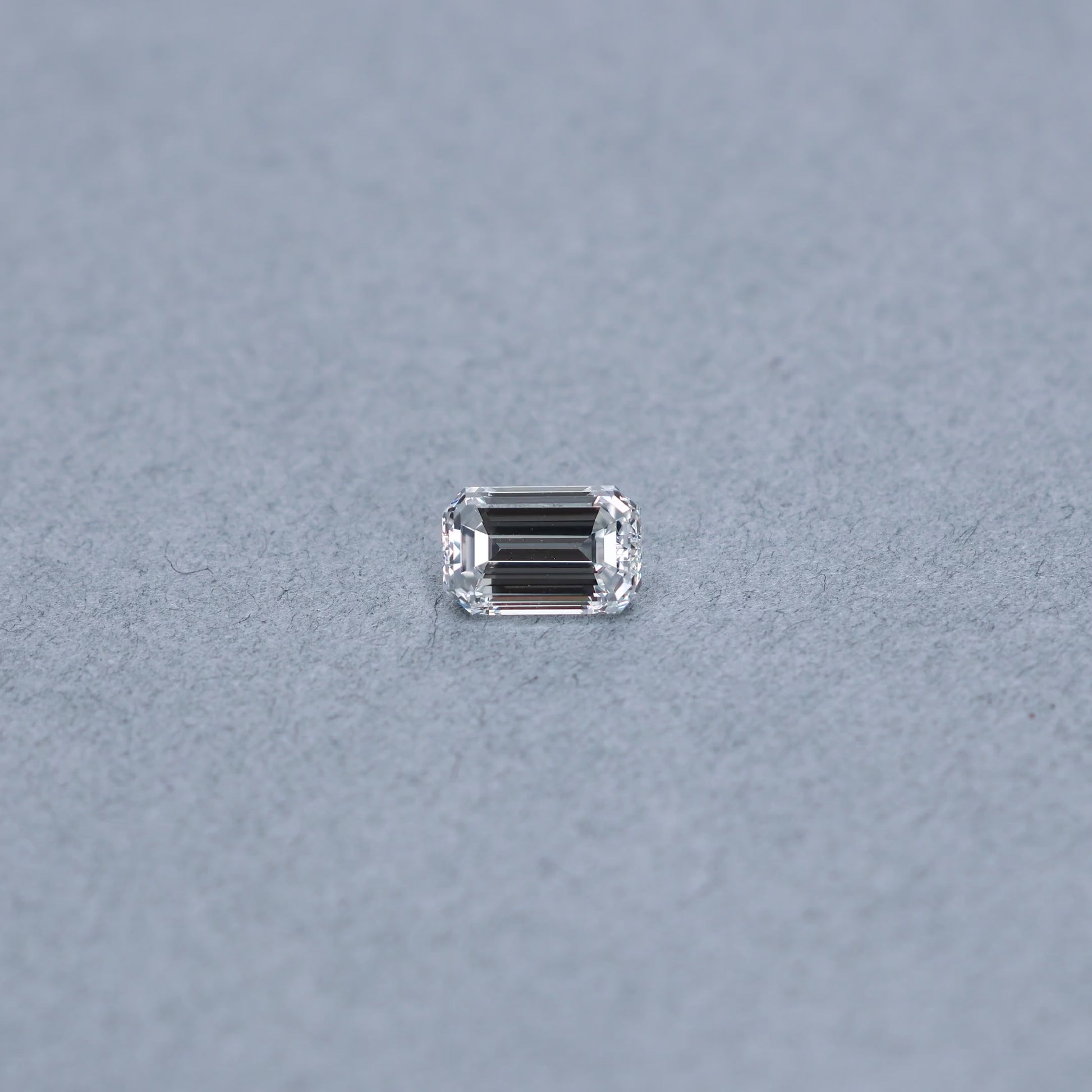 Emerald cut 1.52 carat GIA certified diamond graded FVS2 on a grey background