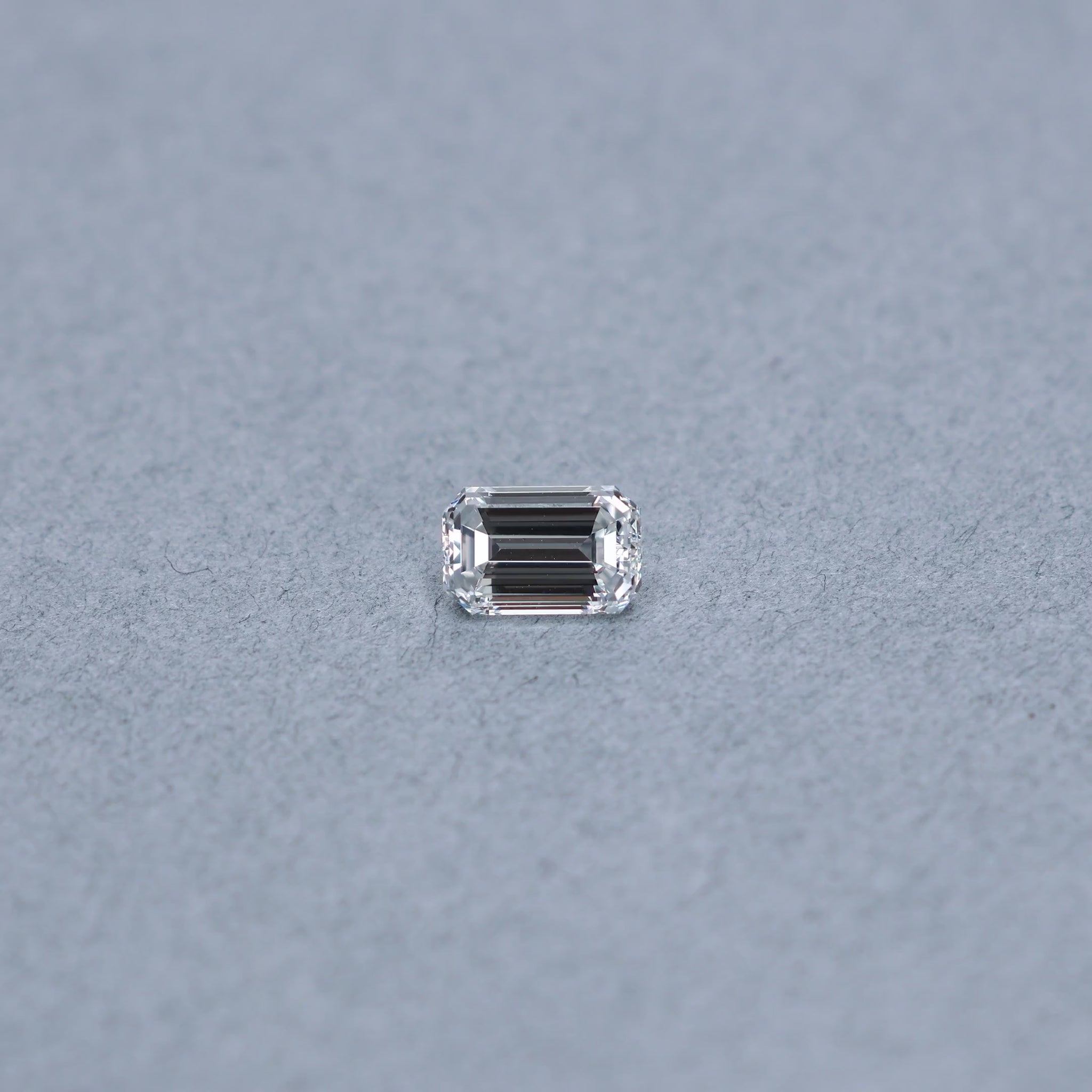 Emerald cut 1.52 carat GIA certified diamond graded FVS2 on a grey background