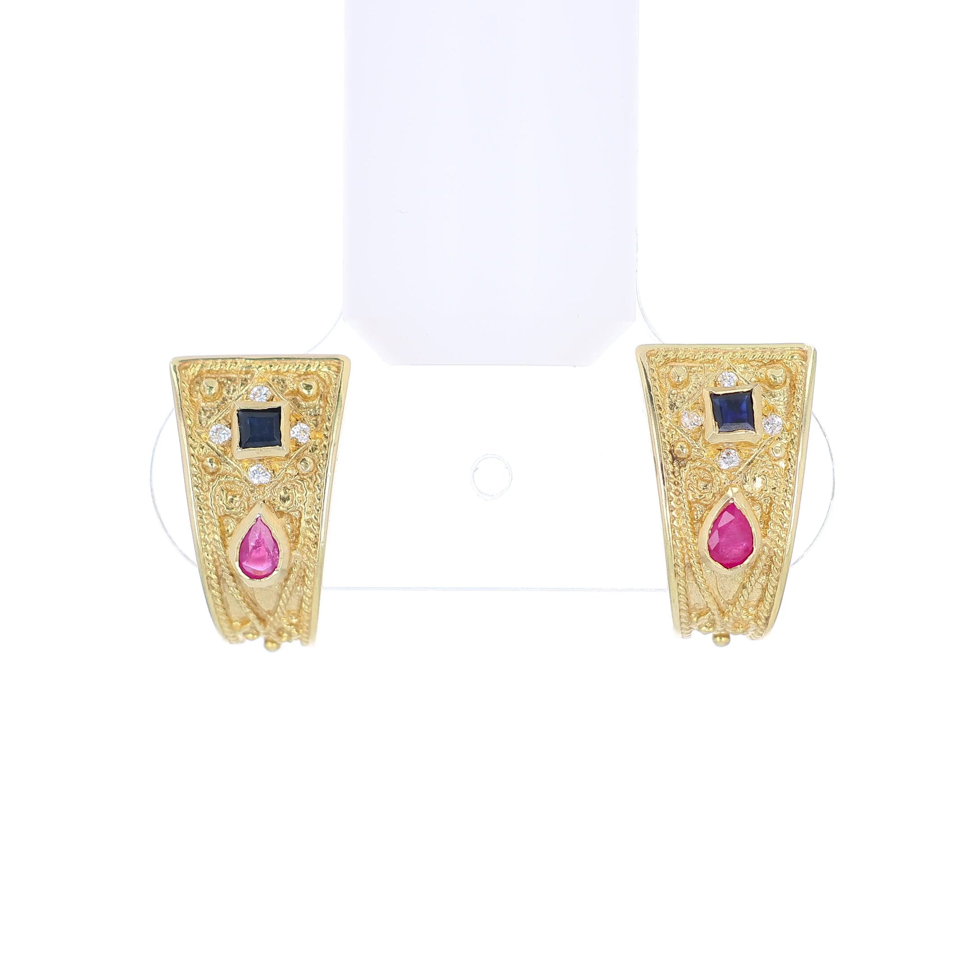 Gold earrings with rubies, sapphires, and diamonds on a white background
