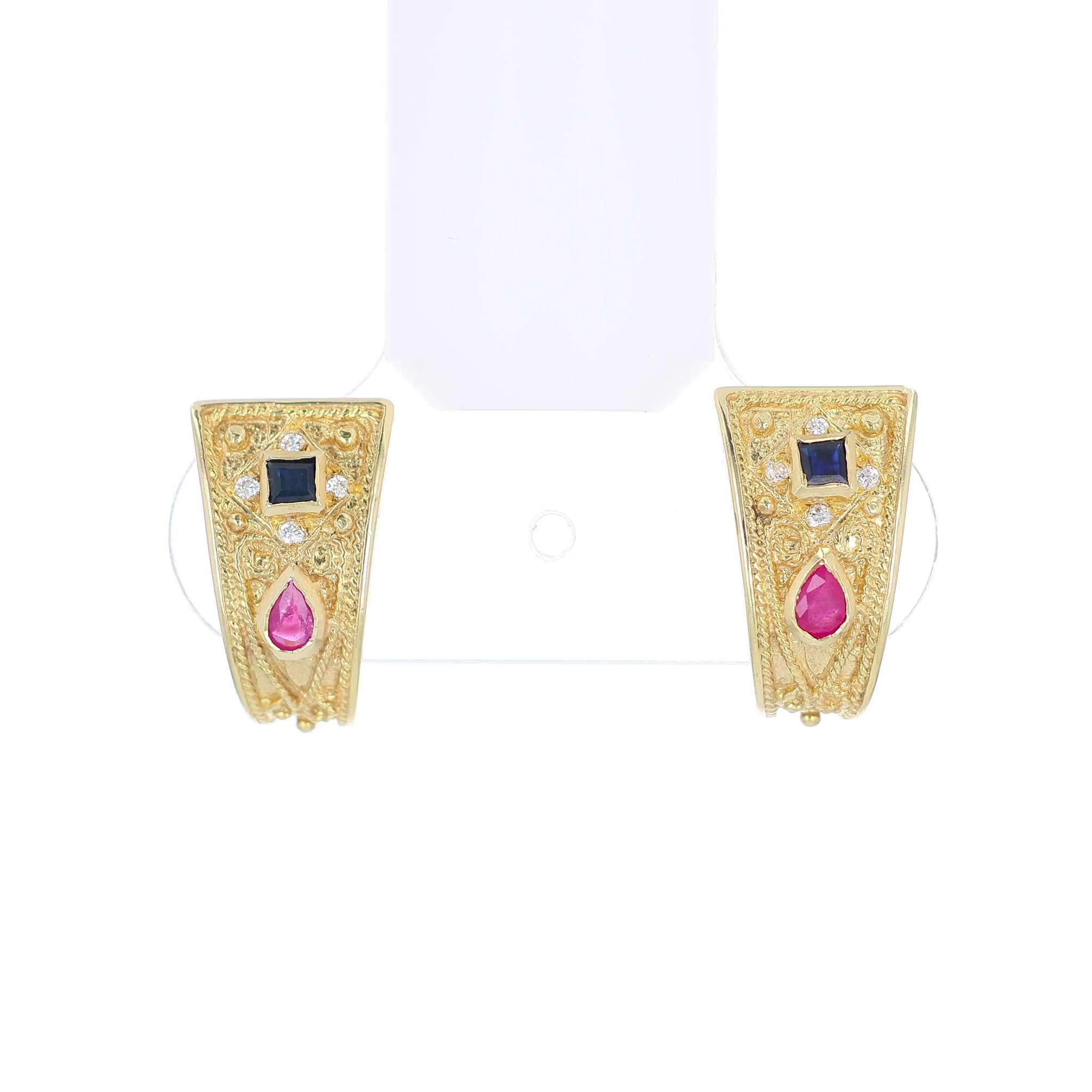 Gold earrings with rubies, sapphires, and diamonds on a white background