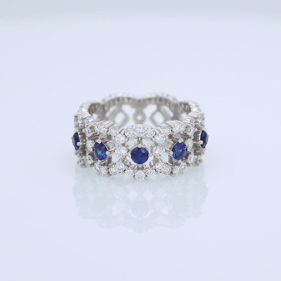 White gold open work band with diamond and blue sapphire accents on a white background