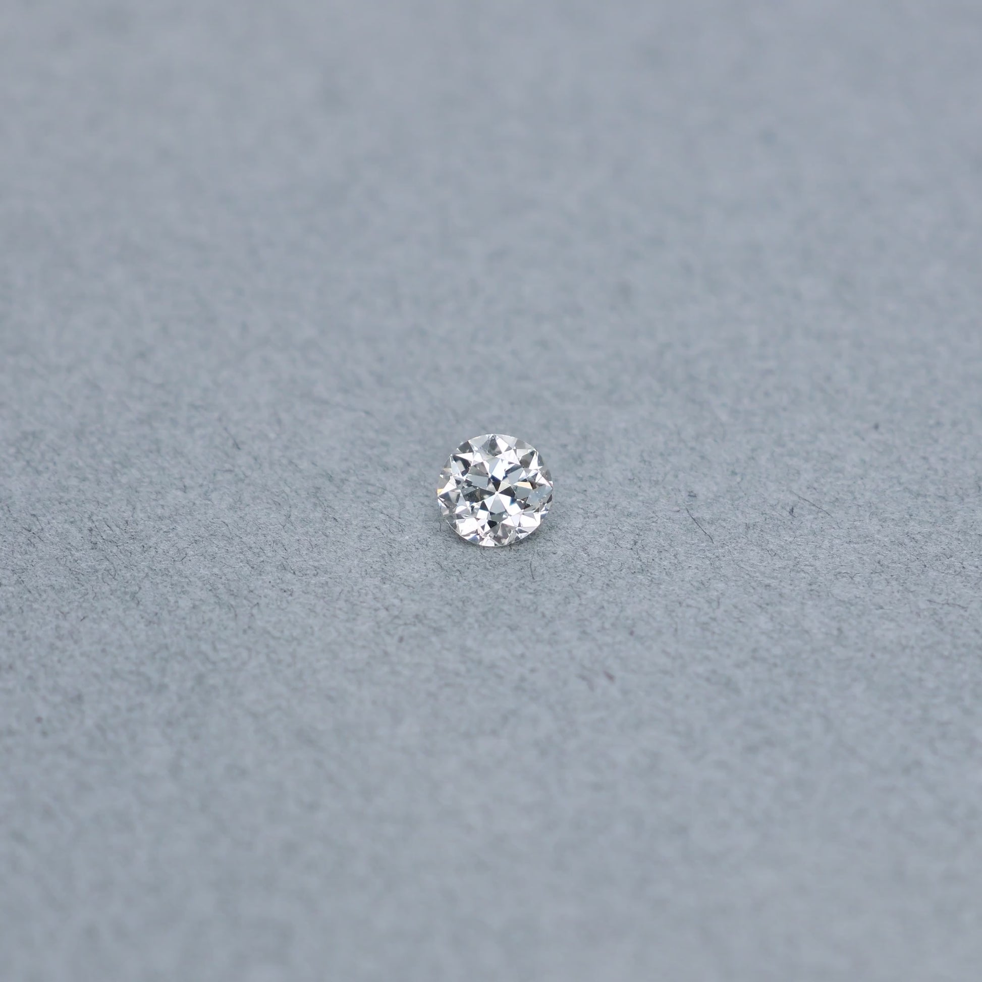 Old european .54 carat diamond graded IVS2 on a grey background