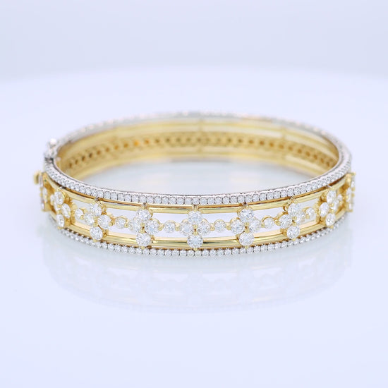 Two-tone gold bracelet with diamond edge and center accents on a white background