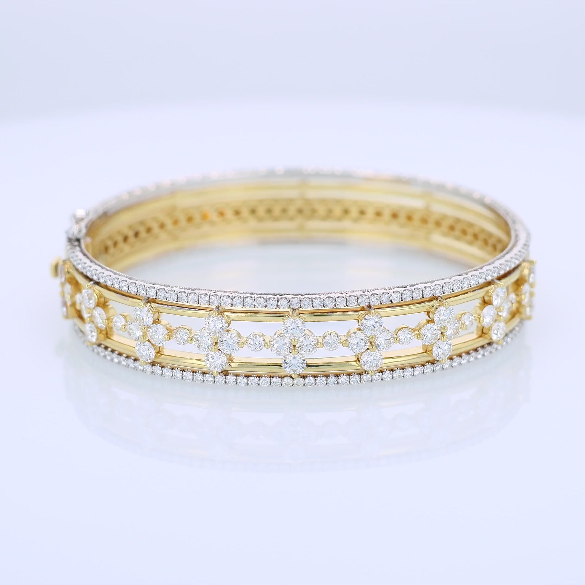 Two-tone gold bracelet with diamond edge and center accents on a white background