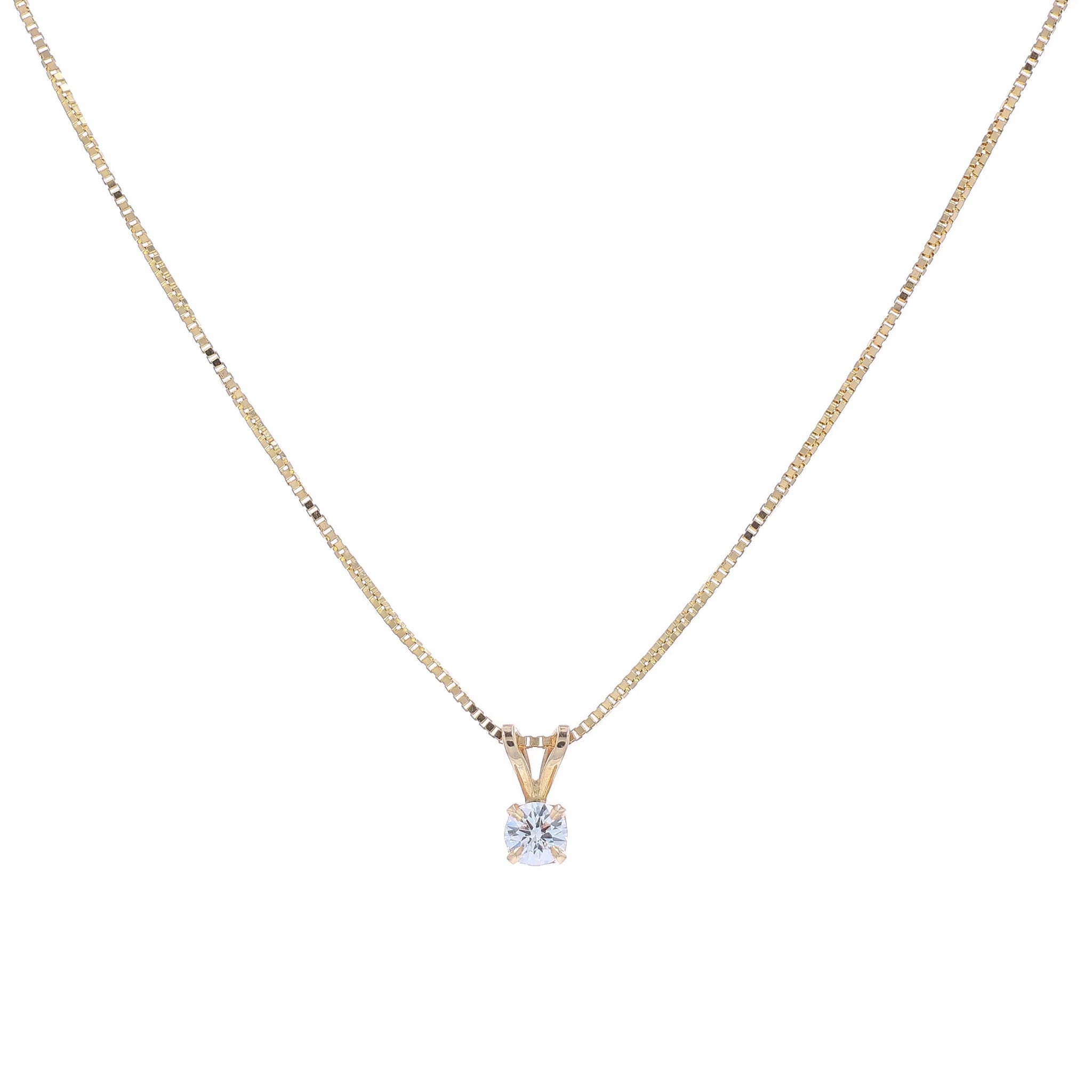 A delicate gold chain necklace with a small pendant holding a clear round-cut diamond, displayed against a solid white background.