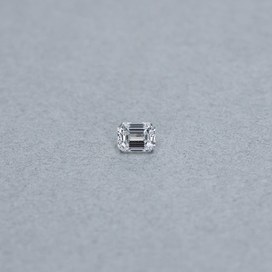 Emerald cut 1.01 carat GIA certified diamond graded FVS1 on a grey background