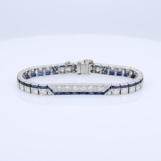 Platinum diamond bracelet with synthetic sapphire accents on a white background